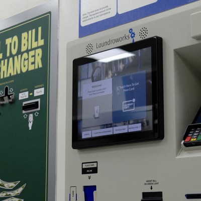 Laundroworks laundry card kiosk touchscreen next to the bill changer at Fresh Fold Brooklyn